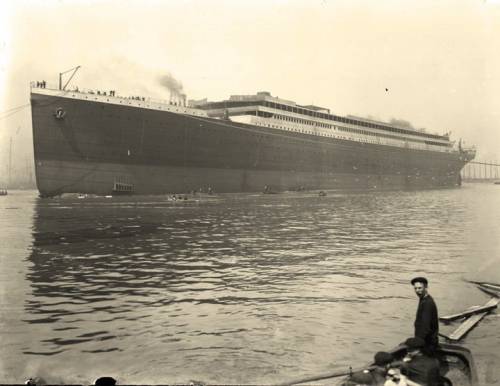 Полдень 31 мая 1911 года. Титаник закрепляют сразу же после спуска на воду. Люди в лодках, убирают плавающий мусор, возникший в следствии движения судна со стапелей.