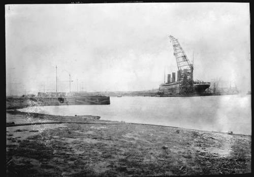 14 февраля 1912 года. Титаник уже две недели находится в сухом доке.На заднем плане, справа от кормы можно заметить стапели, на которых несколько месяцев назад, началось строительство нового лайнера класса Олимпик - позже его назовут Британником.